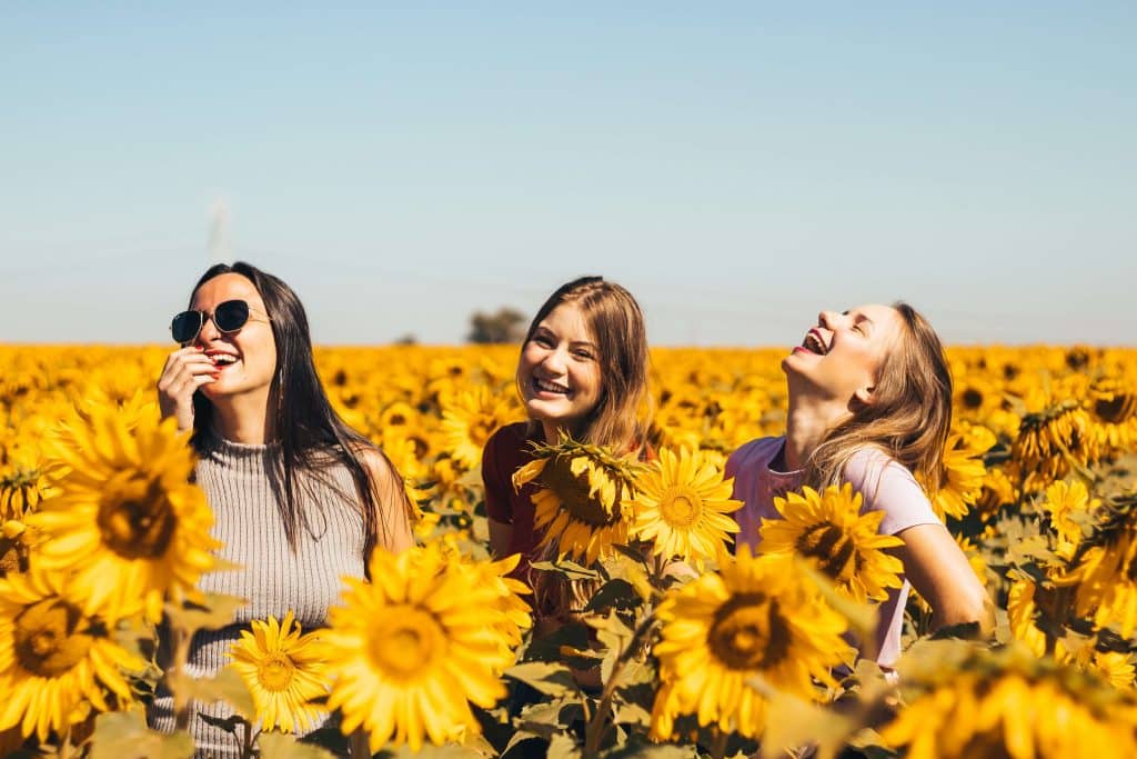 Women Smiling In Sunflower Field